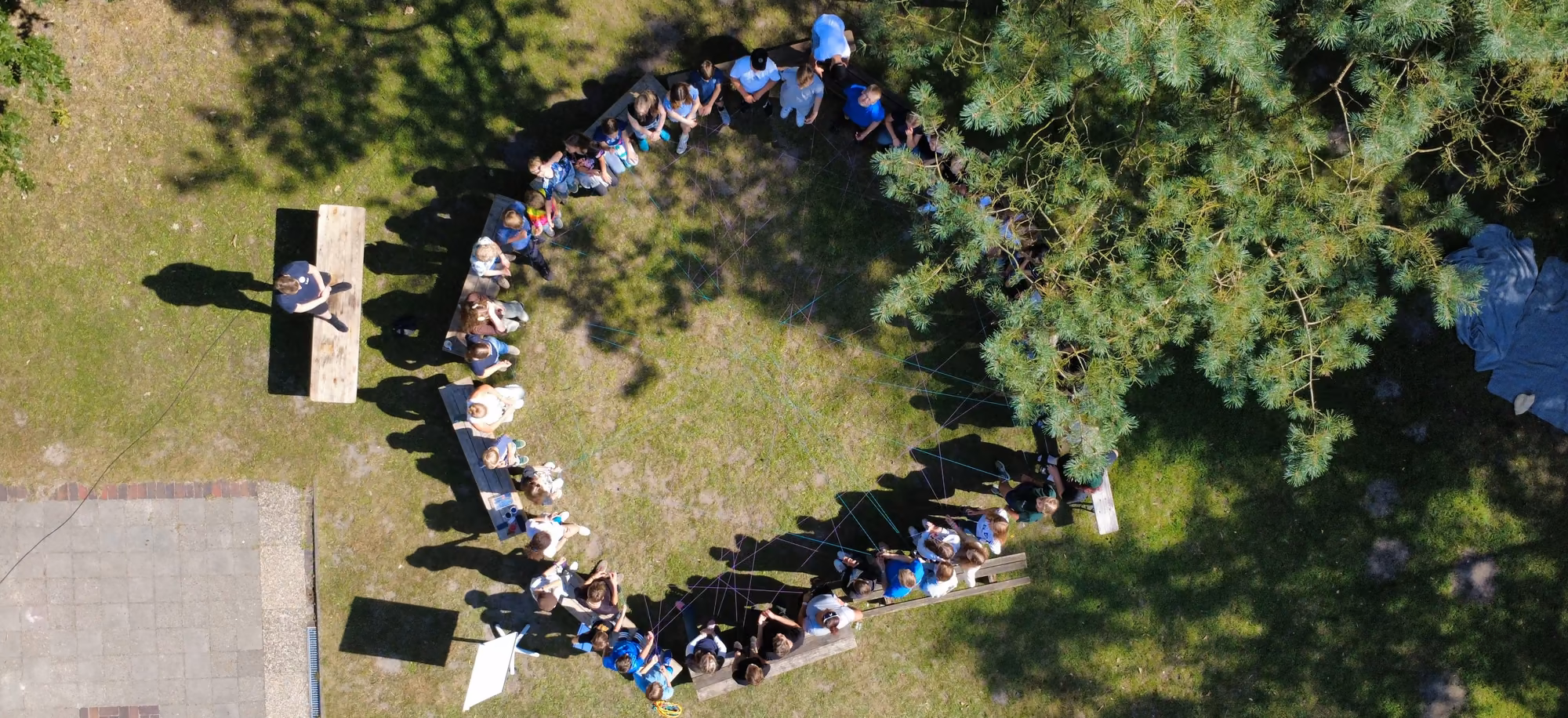Die Gruppe sitzt im Kreis auf dem Gelände